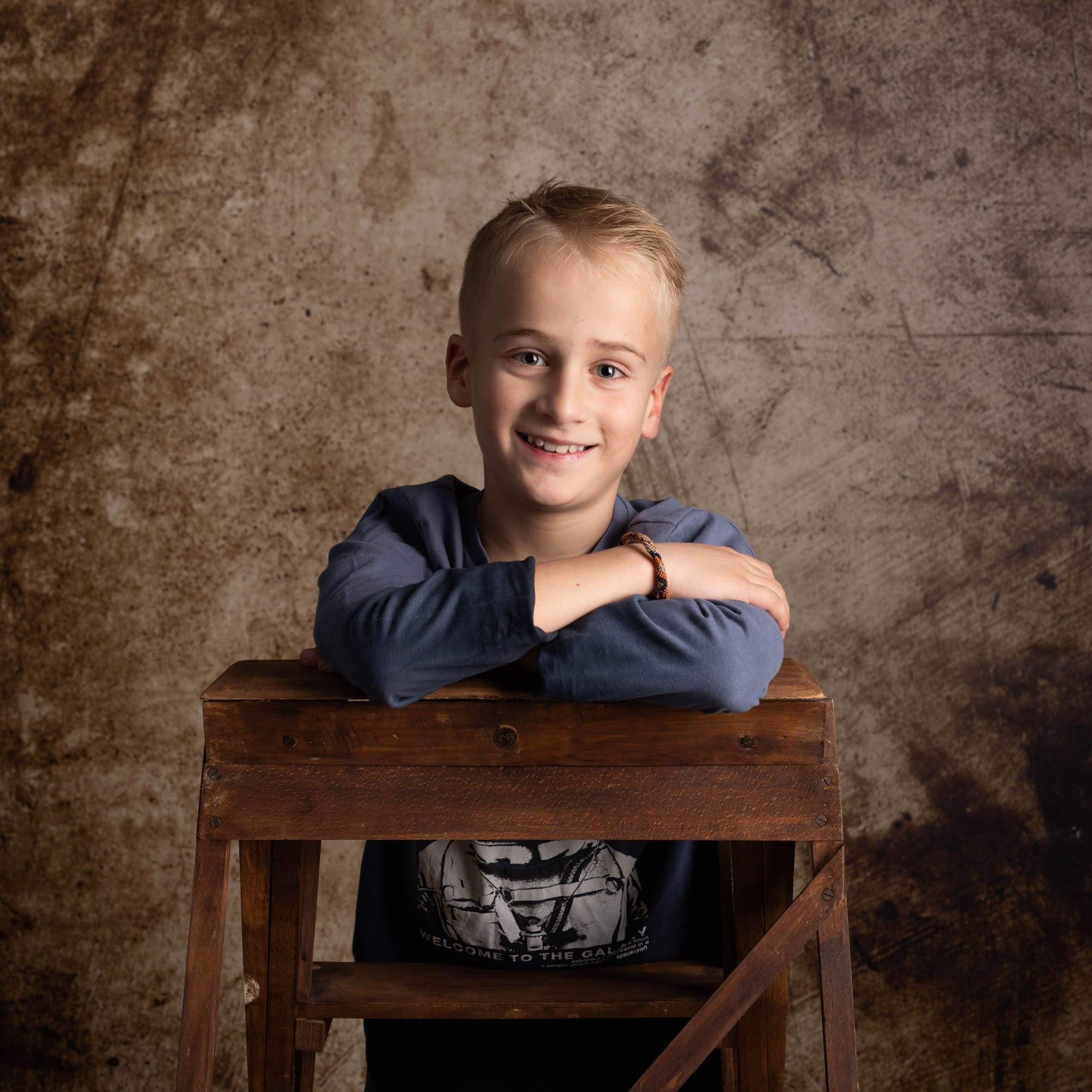 Portrait studio d'un jeune garçon souriant sur fond texturé, Olivia Blanquet Photographe Nice.